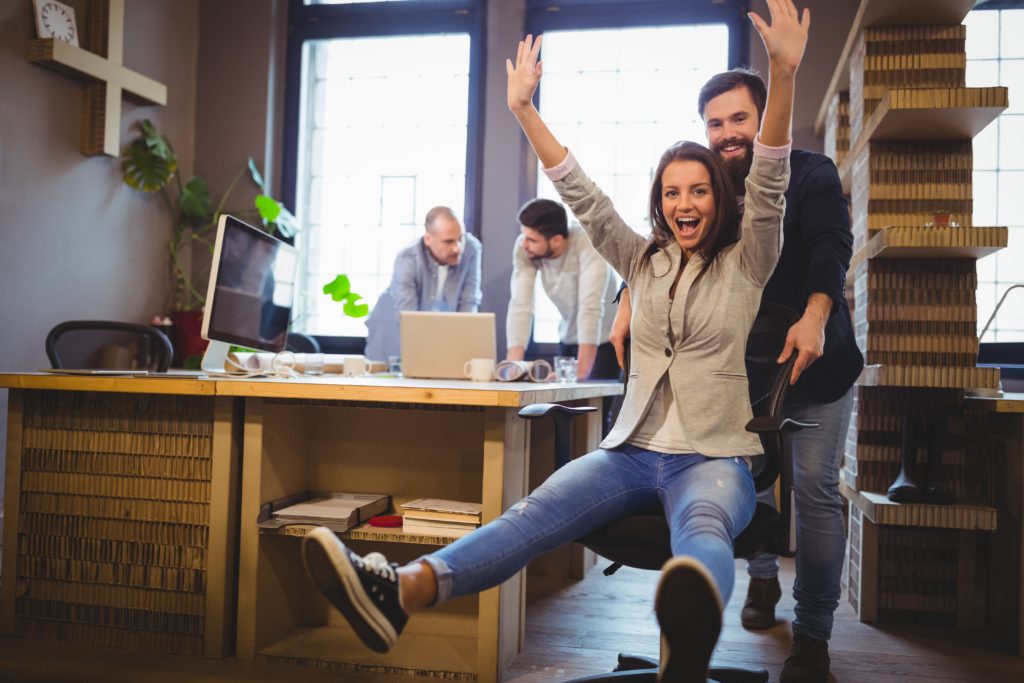happy coworkers having fun on pre-owned used office desks and chairs