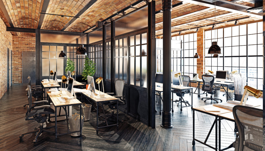 Still of the interior of a modern office aligned with wooden features, divided work spaces, office chairs, and office tables. 