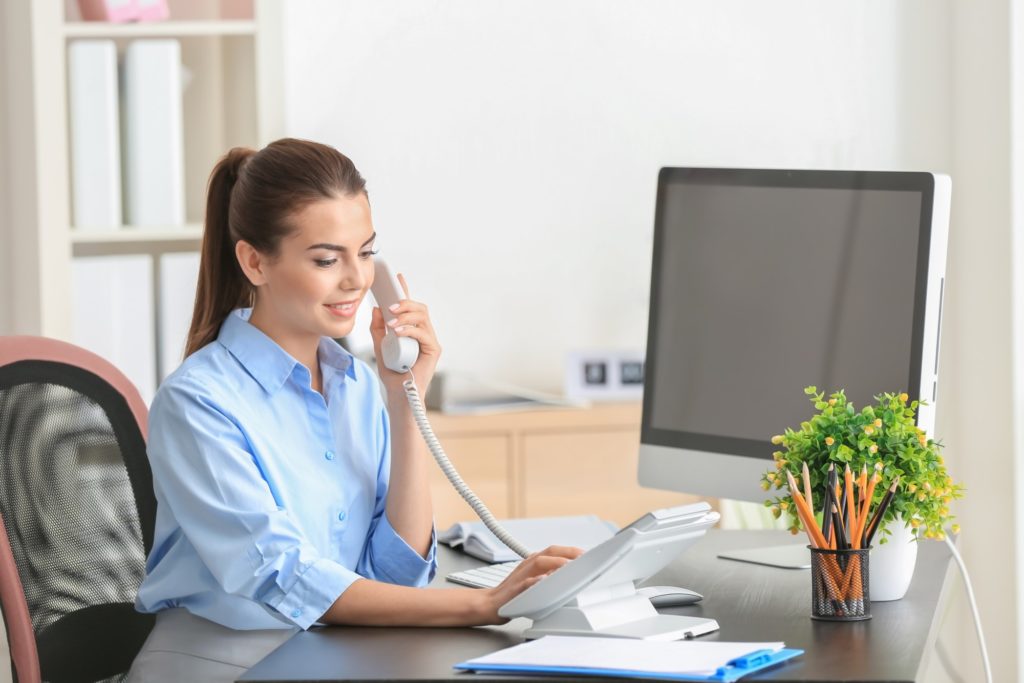 Receptionist area with woman working and on the phone