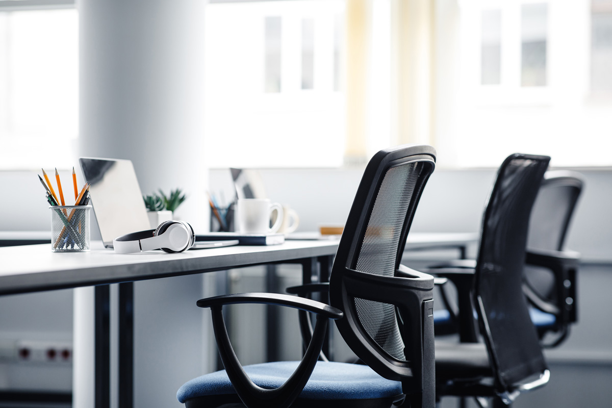 A long desk with three black office chairs in an El Paso office.