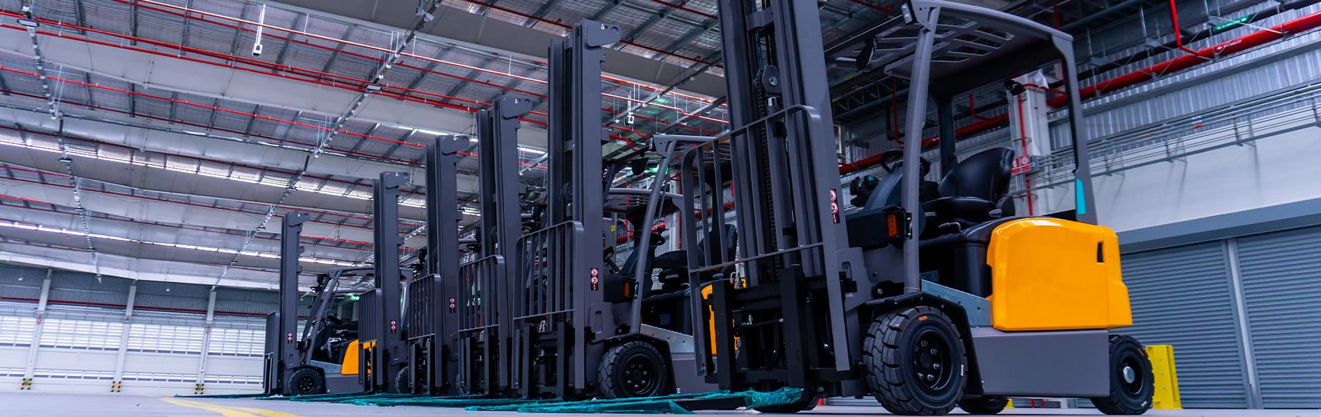 Group of forklifts truck in large warehouse with industrial equipment